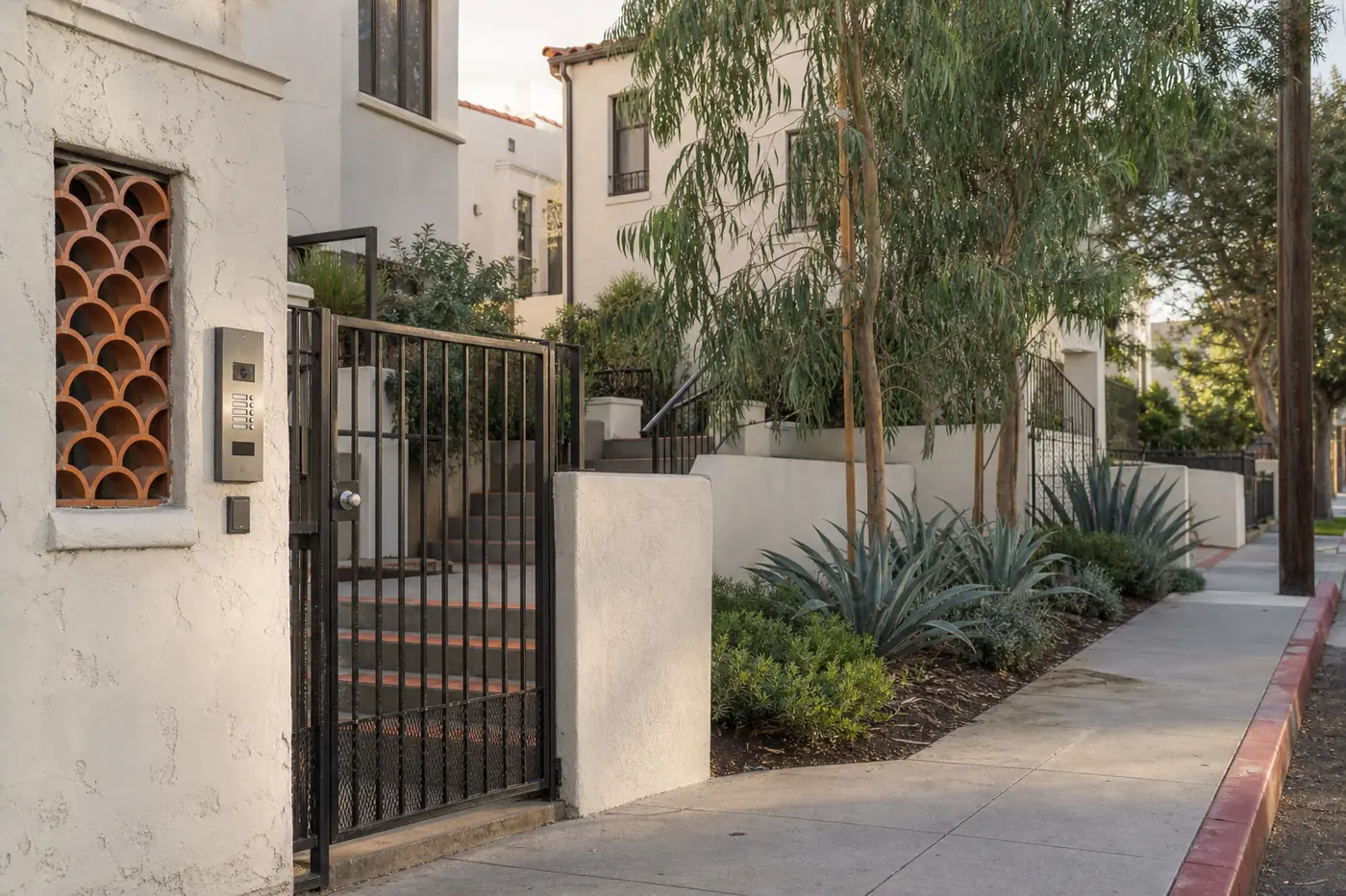 Los Angeles apartment entrance with gate, intercom, steps, and curb access